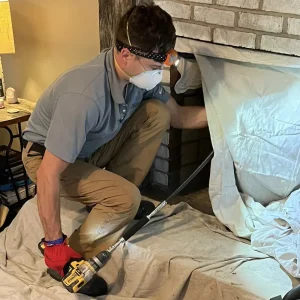 A chimney sweep service in Newport News VA being performed by a certified professional from Premier Chimney and Roofing.
