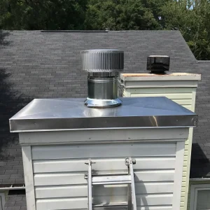 Chimney chase cover with ¼" drip edge and cross breaks installed to improve water runoff and prevent standing water.