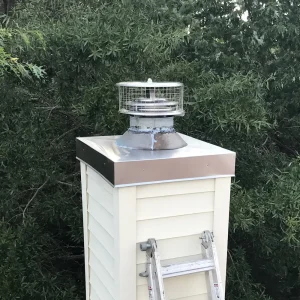 New stainless steel chimney chase cover installed by Premier Chimney and Roofing, featuring cross breaks and drip edge for leak prevention.
