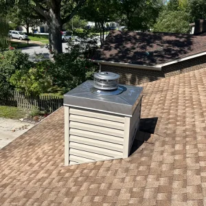 Newly replaced stainless steel chimney chase cover installed by Premier Chimney and Roofing with drip edge and cross breaks for long-term leak protection.