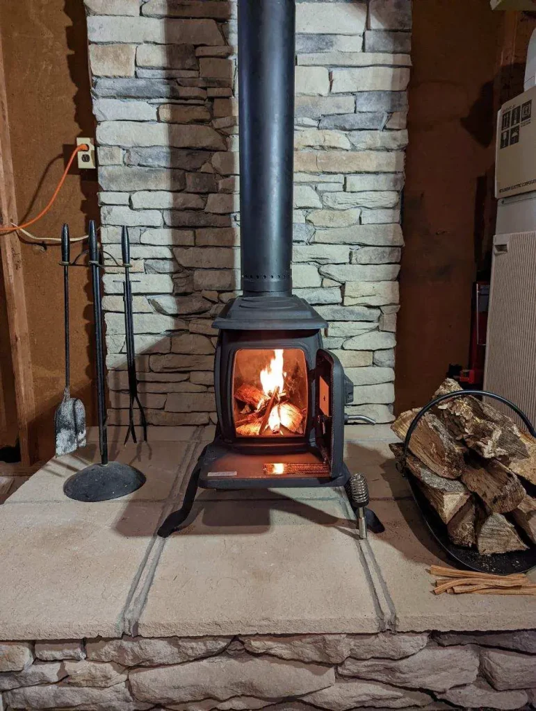 Freestanding wood stove in Chesapeake, VA actively burning with visible flames after professional installation and chimney connection.