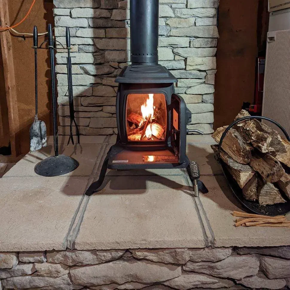 Freestanding wood stove in Chesapeake, VA actively burning with visible flames after professional installation and chimney connection.