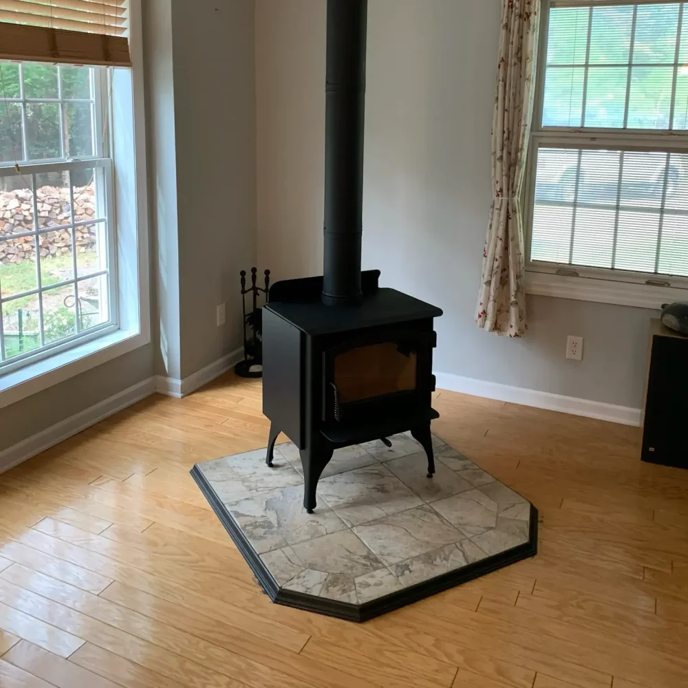 Idle freestanding stove installed in Hampton, VA on a custom tile hearth pad with proper venting through the roof.