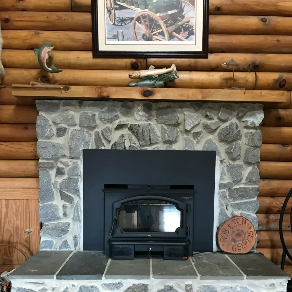New wood stove insert installed into existing masonry fireplace in Chesapeake, VA with surround trim and sealed liner connection.