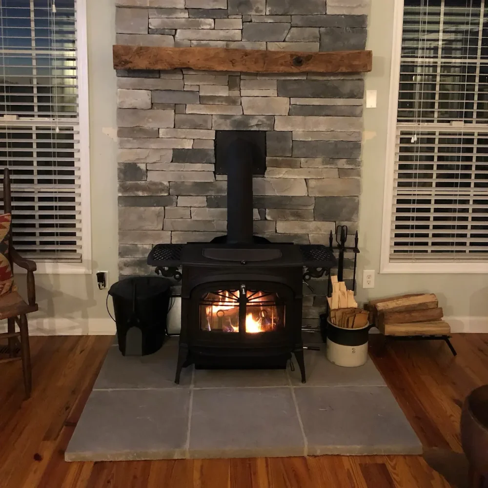 Freestanding wood stove fully installed in Virginia Beach, VA with proper venting, hearth protection, and code-compliant clearances.