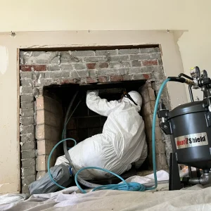 A person performing a chimney relining repair by Premier Chimney and Roofing.