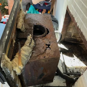 A chimney sweep for a wood stove insert in Virginia Beach by Premier Chimney and Roofing.