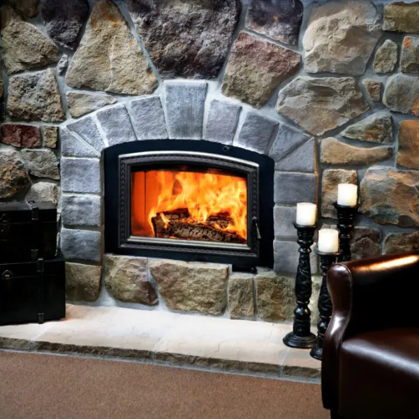 RSF Opel high-efficiency wood-burning fireplace with decorative arch door and custom natural stone surround.